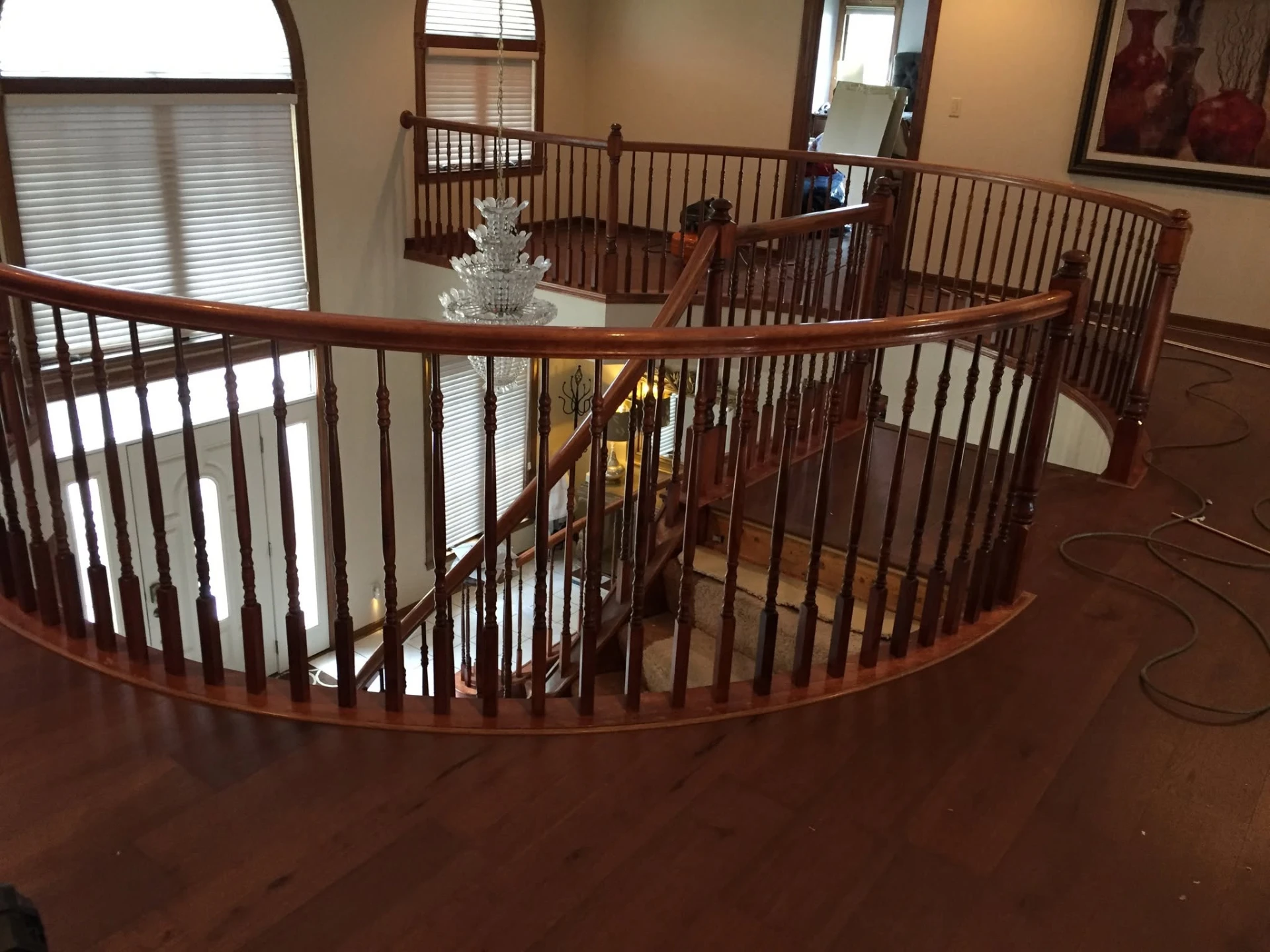 Curved hardwood staircase landing with refinished wood flooring in a Cleveland area home
